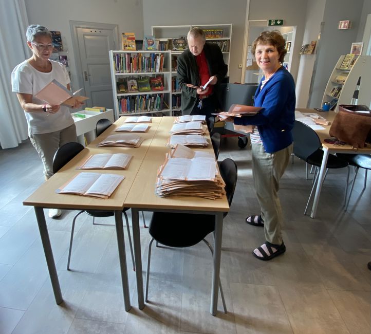 en gruppe mennesker som står rundt et bord med valgsedler