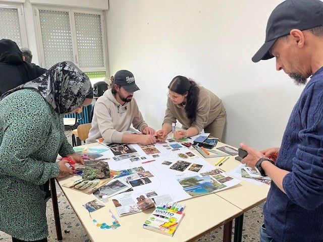 en gruppe mennesker som sitter rundt et bord og lager kollasj