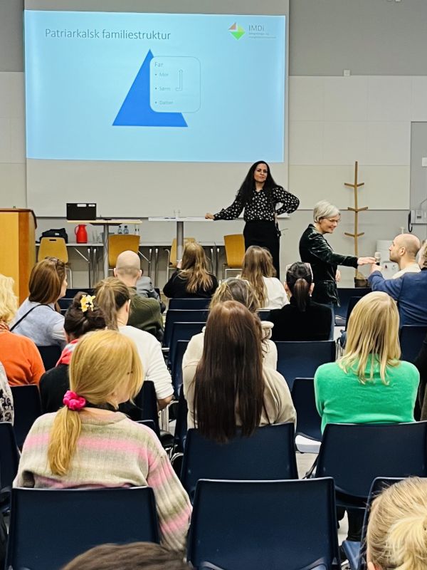 Mangfoldsrådgiver Amna holder en presentasjon for en gruppe og svarer på spørsmålmennesker