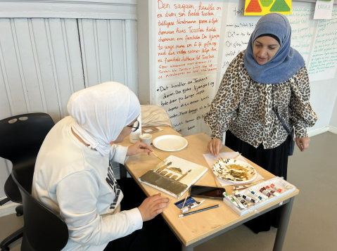 et par personr i hodeskjerf som sitter ved et bord med mat