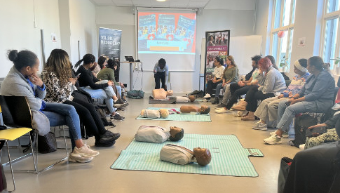 Oslo VO Rosenhof. Deltakerrådet i Osterhaus’ gate inviterte til førstehjelpskurs i regi av MIRA-senteret en gruppe mennesker som sitter i et rom og blir kurset i hjerte-lunge-redning