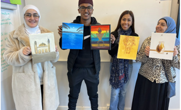 en gruppe mennesker som holder frem bilder de har malt