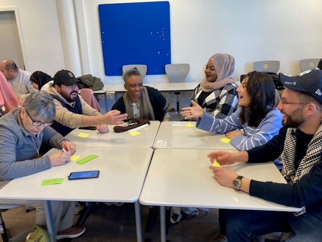 en gruppe mennesker som sitter rundt et bord