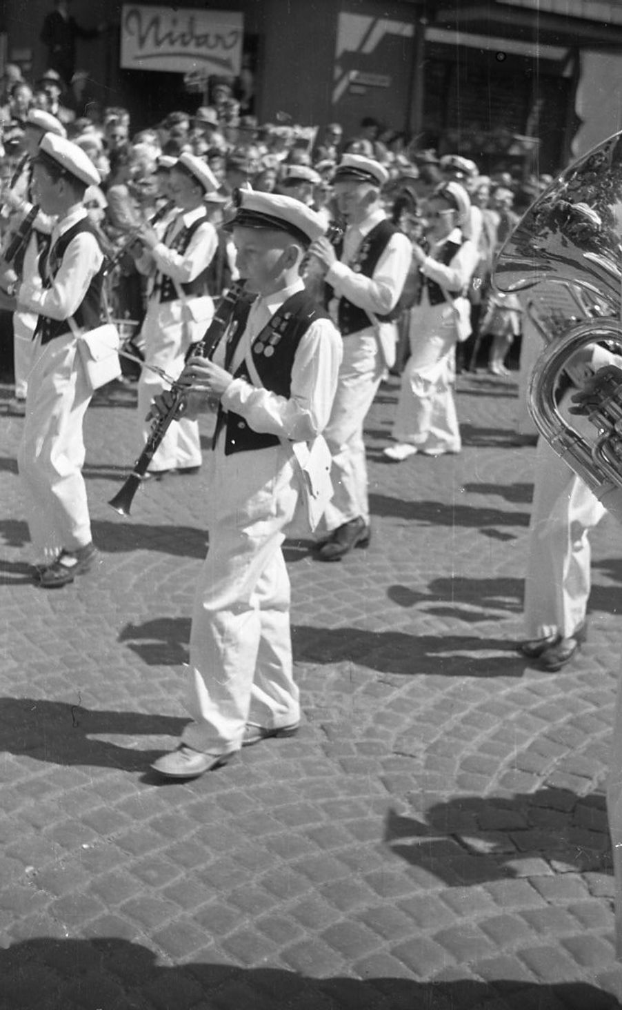 Foto: Korpset på Karl Johan en tidligere 17. mai, kanskje ca 1952. Korpset på Karl Johan en tidligere 17. mai, kanskje ca 1952. En gutt spiller klarinett.