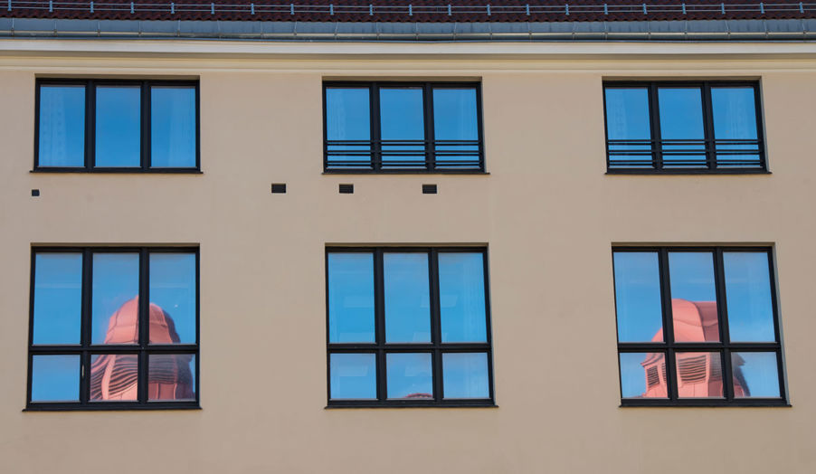 Bilde av vinduer i Dynekilgata, der man kan se speilbilde av piper fra taket Bilde av vinduer i Dynekilgata, der man kan se speilbilde av piper fra taket