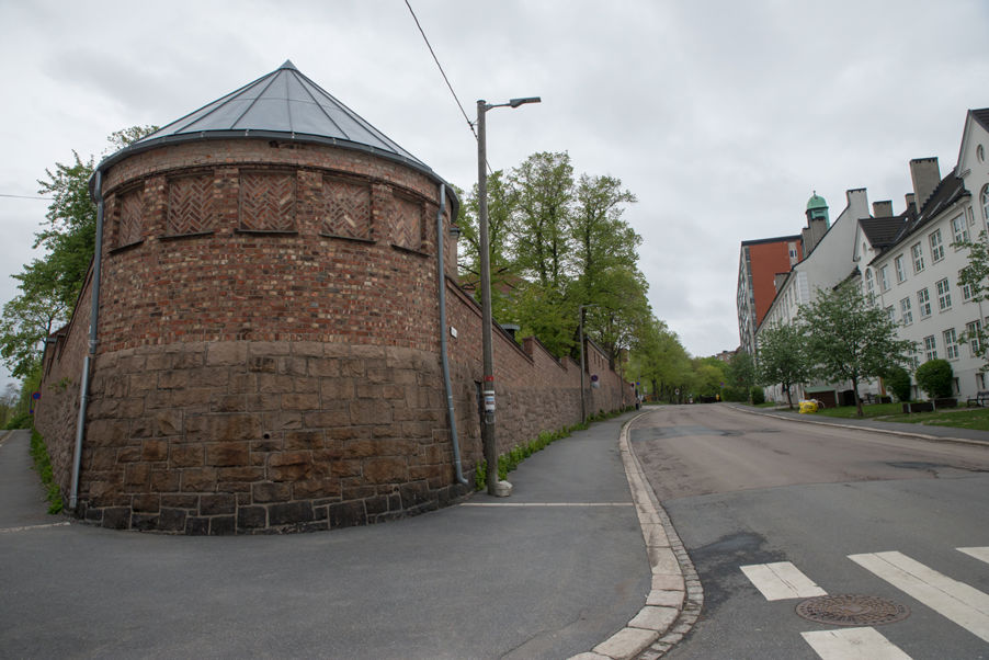 Foto: Dynekilgata i mai Bilde av tårnet i Dynekilgata. Muren går på hver siden av tårnet. Det er ingen biler i gata.