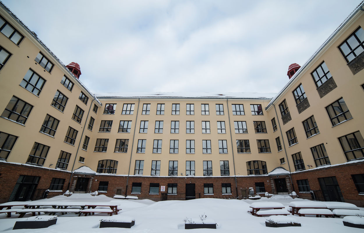 Bilde av Dynekilgata 10 med skolegården i front. Det er mye snø på bord og benker.