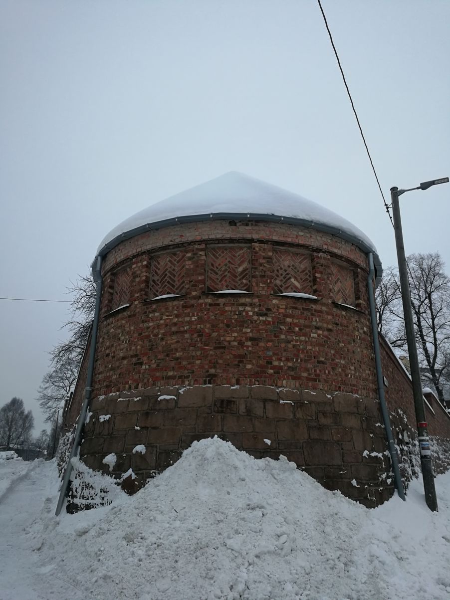 Foto: Tårnet i enden av skolegården i Dynekilgata 10 Tårnet i enden av skolegården i Dynekilgata 10. Det er i rød murstein og det er mye snø foran.