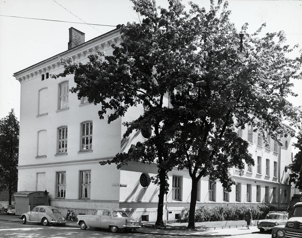 Framhaldsskolen, cirka 1961. Fotograf: Eidem, Olav Lorck. Oslo Museum/OB.FS0630 Bilde av Framhaldsskolen i 1961. To gammeldagse biler er parkert foran skolen.