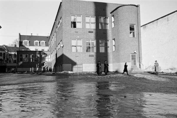 Flomvann i skolegården i Osterhaus gate i 1939. Barn leker i vannet.