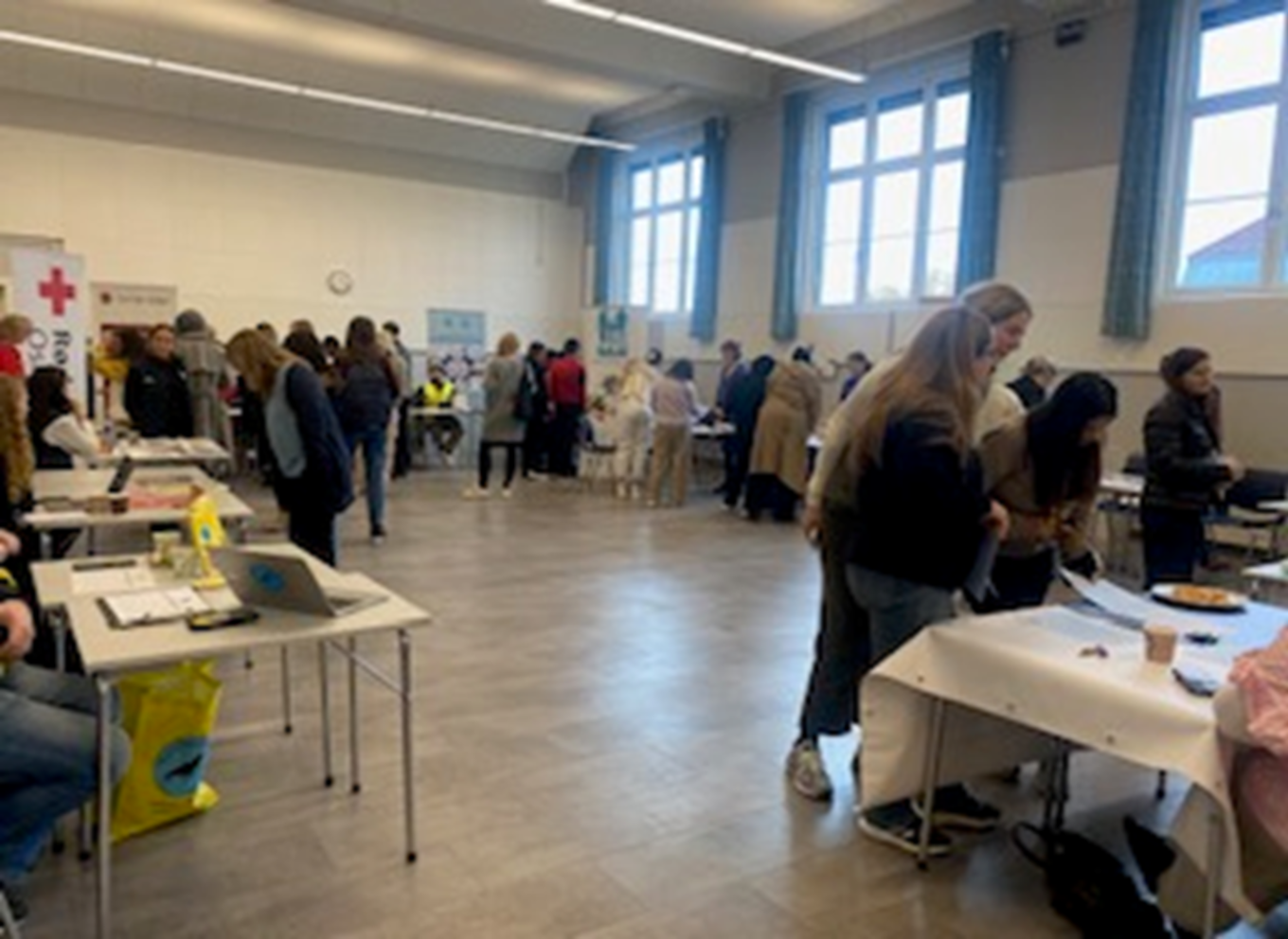 en gruppe personer i et rom med stands