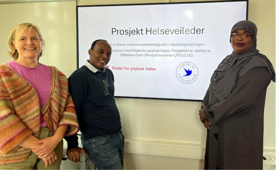 noen få mennesker som står foran en stor skjerm